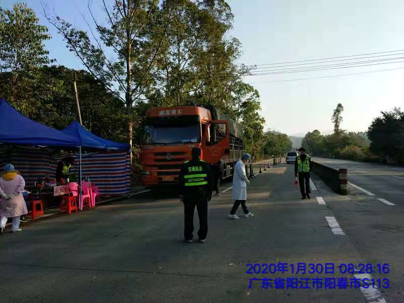 圖為交通行政執法人員在春灣鎮入市通道協助醫務人員排查過往車輛.jpg